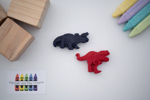 Crayons shaped as standing on all four legs Triceratops. and standing roaring t-rex