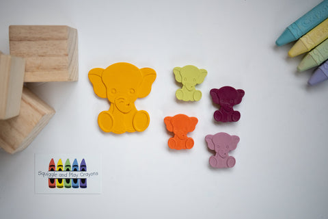 One large sitting elephant crayon with four small sitting elephant crayons. All different colours 