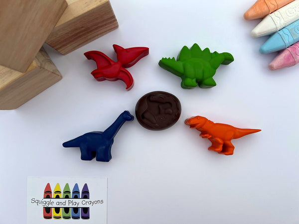 crayons in shapes of flying pterodactyl, standing stegosaurus, standing t-rex, standing brachiosaurs, round shaped egg with baby dino on the front 