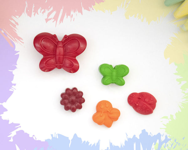 A large, dark red butterfly crayon, with 4 small crayons in the shape of a butterfly, a bee, a ladybird, and a flower