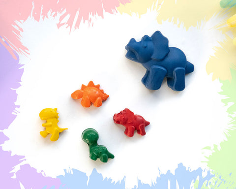 A large, blue stegasaurus crayon with 4 smaller crayons, a brachiosaurus, a triceratops, a stegosaurus, and a t-rex