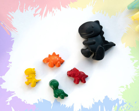 A large, black t-rex crayon with 4 smaller crayons, a brachiosaurus, a triceratops, a stegosaurus, and a t-rex