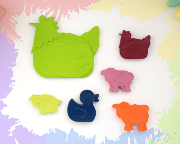 A large, lime green sitting chicken crayon with 5 smaller crayons, a duck, a chicken, a pig, a sheep, and a cow