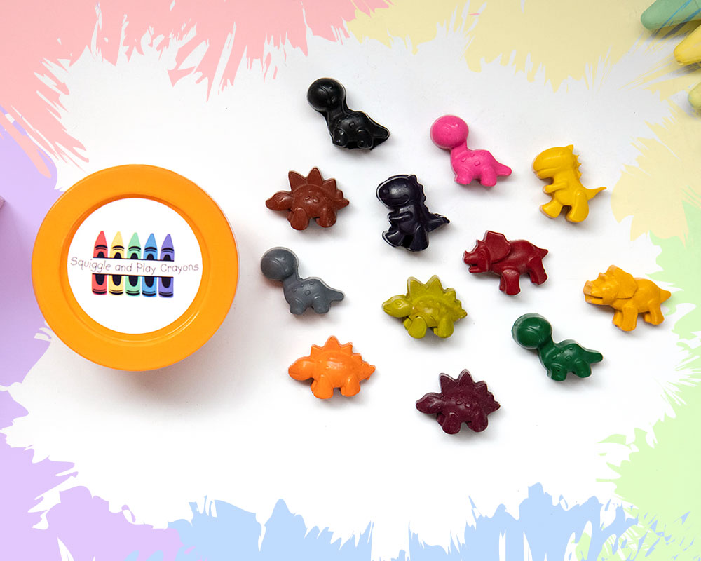 A round, orange-lidded tub with an assortment of small, coloured, cartoon dinosaur crayons