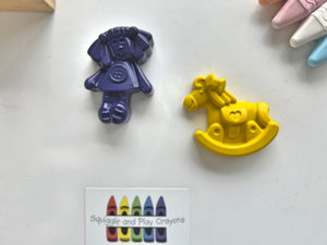 crayons in the shaped of a doll with her hair in pigtail arms by her side standing, button on front of dress. Rocking horse with hair on head and bow in hair. heart shape on saddle