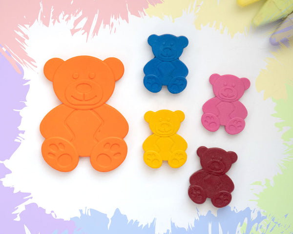 A large, orange crayon in the shape of a 2D teddy bear, with 4 smaller versions